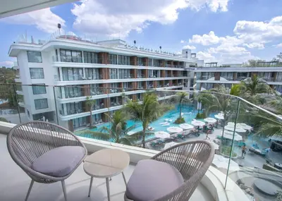 a balcony with chairs and a view of a hotel at Kora 267 3BR Condo with Pool View in Phuket Town