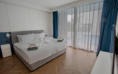 a bedroom with a white bed and a large window at Kora 222 3BR Condo with Pool Access in Phuket Town