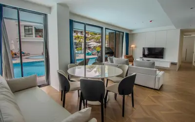 a living room with a couch and a table and chairs at Kora 222 3BR Condo with Pool Access in Phuket Town