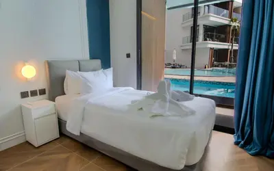 a bedroom with a large bed and a swimming pool at Kora 222 3BR Condo with Pool Access in Phuket Town