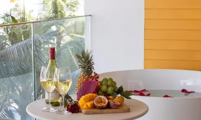 a table with two glasses of wine and a tray of fruit at One Bedroom Wyndham Naithon with Jacuzzi in Phuket Town