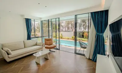 a living room with a couch and a pool at Kora 77 2BR Beachfront Condo with Sea View and Pool in Phuket Town