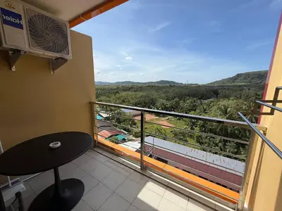 a room with a table and a balcony with a view at FAMILY HOMES Mai Khao Poolside Studio CB-845 Near Sirinat Park in Ban Mai Salae