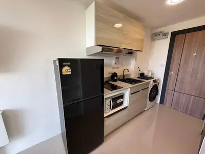 a kitchen with a black refrigerator and a stove at FAMILY HOMES Mai Khao Poolside Studio CB-845 Near Sirinat Park in Ban Mai Salae