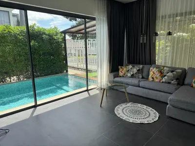 a living room with a couch and a swimming pool at Villa DIAZ RAWAI in Ban Saiyuan (1)