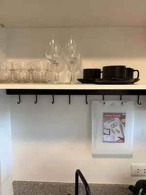 a shelf with wine glasses and a plate on it at The Signature Studio at Mai Khao by FAMILY HOMES CB-846 in Ban Mai Salae