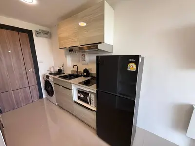 a kitchen with a black refrigerator and a stove at The Signature Studio at Mai Khao by FAMILY HOMES CB-846 in Ban Mai Salae