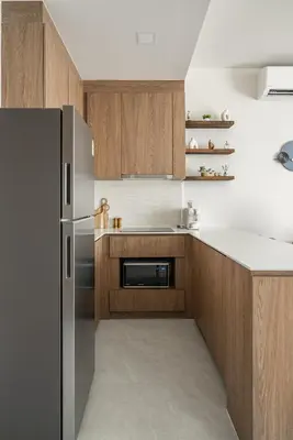 a kitchen with a stainless steel refrigerator and wooden cabinets at Canvas Apartments in Laguna Phuket