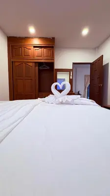 a large white bed with a heart decoration on it at เดอะ รินรา กมลา ฮัท in Kamala Beach
