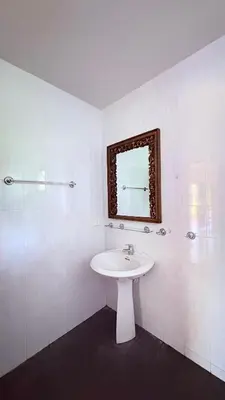 a white bathroom with a sink and a mirror at เดอะ รินรา กมลา ฮัท in Kamala Beach