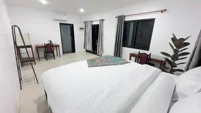 a white bed in a white room with windows at Watermelon House at Nong Thale Garden & Kitchen in Ban Khao Klom