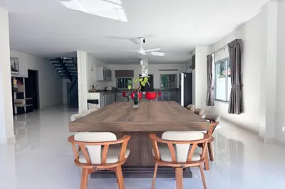 a dining room with a wooden table and chairs at Grand Villa Ishu 4BR Private Pool in Kamala Beach