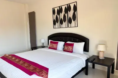 a bedroom with a large white bed with red pillows at Grand Villa Ishu 4BR Private Pool in Kamala Beach