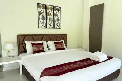 a bedroom with a large bed with white and red pillows at Grand Villa Ishu 4BR Private Pool in Kamala Beach