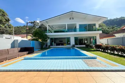 a house with a swimming pool in front of a house at Grand Villa Ishu 4BR Private Pool in Kamala Beach