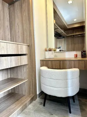 a white chair in a kitchen with wooden cabinets at Laguna villa with private pool in Ban Phru Champa
