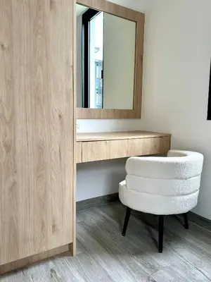 a bathroom with a mirror and a stool and a chair at Laguna villa with private pool in Ban Phru Champa