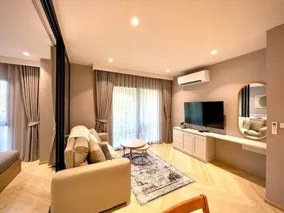 a living room with a couch and a television at Title Legendary Apartment 1 Bdr Bang Tao in Bang Tao Beach
