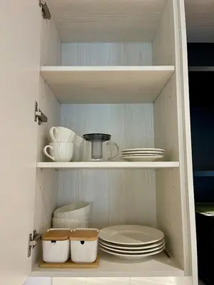 a cabinet filled with plates and bowls and dishes at Title Legendary Apartment 1 Bdr Bang Tao in Bang Tao Beach