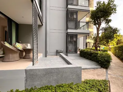 a courtyard of a building with a bench and a building at Cassia Residences Condo in Laguna Phuket in Laguna Phuket