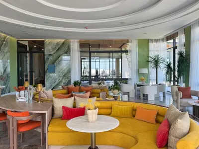 a living room with a yellow couch and colorful pillows at Lovely 2 Bdr Canvas BangTao in Laguna Phuket