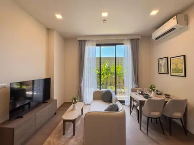 a living room with a couch and a tv and a table at Lovely 2 Bdr Canvas BangTao in Laguna Phuket
