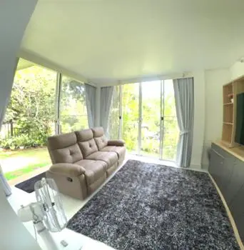 a living room with a couch and a large window at Lai Thai Villa 4 in Rawai Beach