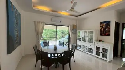 a dining room with a table and chairs and a window at Lai Thai Villa 4 in Rawai Beach