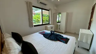 a bedroom with a white bed with a umbrella on it at Lai Thai Villa 4 in Rawai Beach