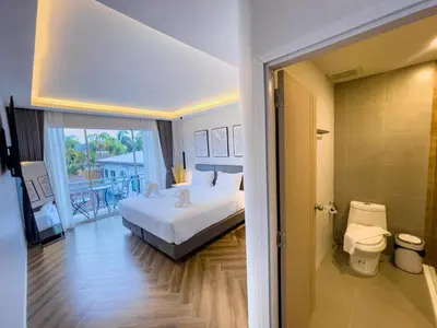 a hotel room with a bed and a balcony at Rawai Lalaland Studio Apartments in Ban Saiyuan (1)
