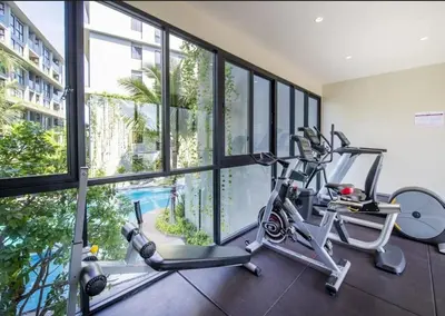 a gym with two exercise bikes in a room with windows at Diamond cozy serviced apartment Bangtao beach 700m in Bang Tao Beach