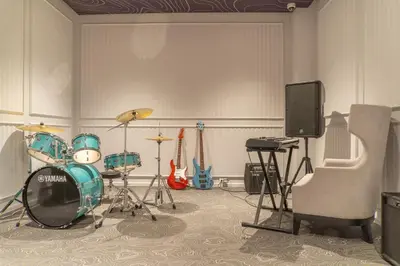 a room with a drum set and a television at Suite Valencia 2BR The Title IBG Legendary BangTao in Laguna Phuket