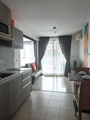 a kitchen and living room with a couch and a table at Centrio phuket 07 in Ban Rangeng