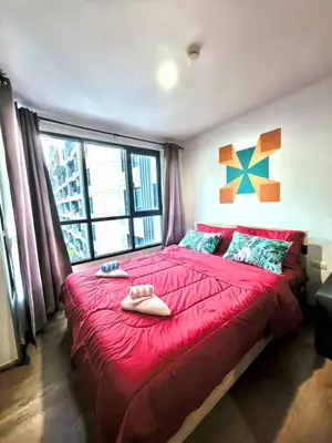 a bedroom with a large red bed with a large window at Centrio phuket 07 in Ban Rangeng