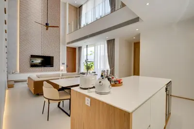 a kitchen and living room with a table and a couch at New 4 bedroom villa 700 meters to Bang Tao Beach in Ban Thalat Choeng Thale