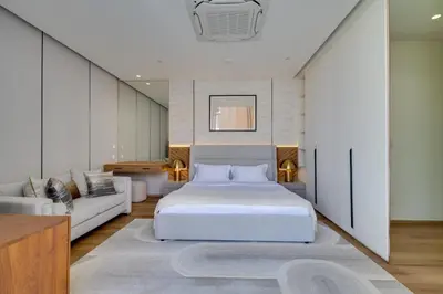 a bedroom with a white bed and a couch at New 4 bedroom villa 700 meters to Bang Tao Beach in Ban Thalat Choeng Thale