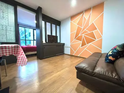 a living room with a couch and a television at centrio Phuket A68 in Ban Rangeng