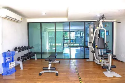 a gym with treadmills and chairs in a room at centrio Phuket A68 in Ban Rangeng