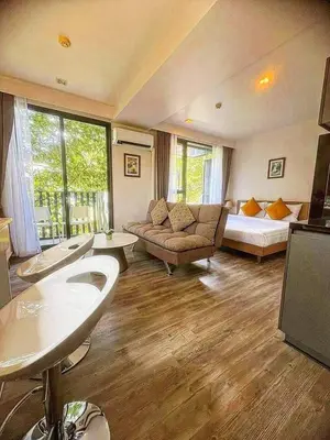 a living room with a couch and a bed at Sunny The Deck Patong Apartment in Patong Beach