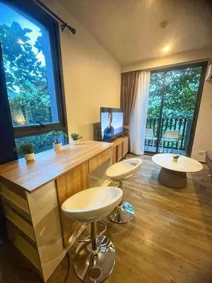 a room with two stools and a large window at Sunny The Deck Patong Apartment in Patong Beach