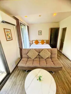 a living room with a couch and a bed at Sunny The Deck Patong Apartment in Patong Beach