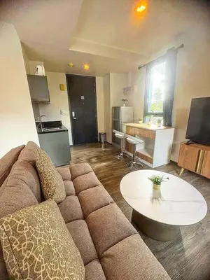 a living room with a couch and a table at Sunny The Deck Patong Apartment in Patong Beach
