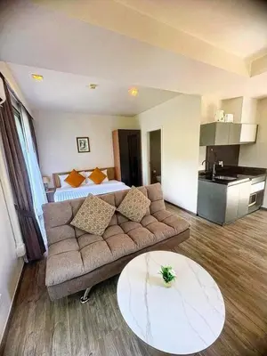 a living room with a couch and a bed at Sunny The Deck Patong Apartment in Patong Beach