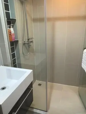 a bathroom with a glass shower and a sink at Sunny The Deck Patong Apartment in Patong Beach