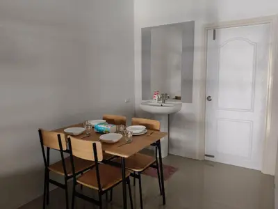 a dining room with a table and chairs and a sink at Jenny Naiyang Beach in Phuket