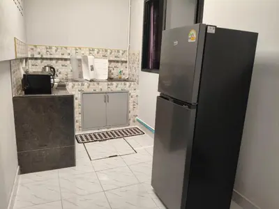 a kitchen with a stainless steel refrigerator in a room at Jenny Naiyang Beach in Phuket