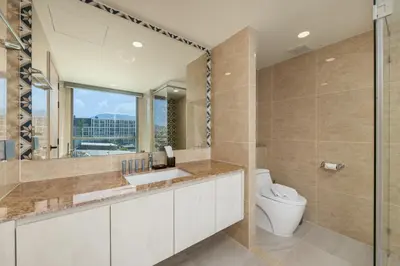 a bathroom with a toilet and a sink and a mirror at Suite Anafi 2BR Pool Gym Access Ozone in Laguna Phuket