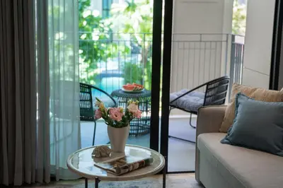a living room with a table with a vase of flowers at Luxury 2 bdr Title Legendary Bang Tao Pool View in Bang Tao Beach