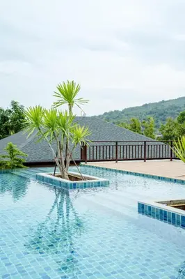 a swimming pool with a palm tree in the middle at 1 Bedroom Villa - 2 Minutes to Nai Harn Beach A103 in Rawai Beach