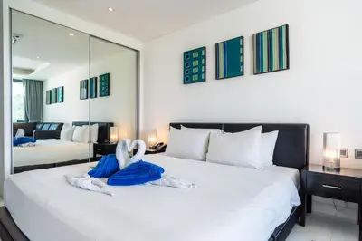 a bedroom with a large white bed with towels on it at Sea view studio near Tri Trang & Merlin beach in Patong Beach